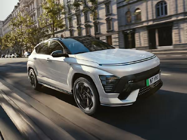 Hyundai KONA Electric car in silver driving down the street