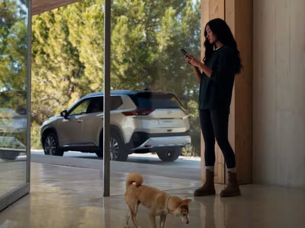 Silver Nissan X-Trail e-Power SUV parked outside with a woman and dog stood in front